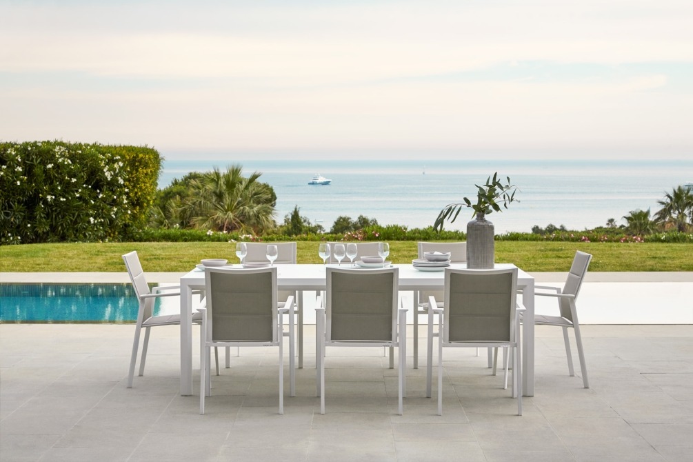outdoor dining table by the pool with batyline chairs and nice view