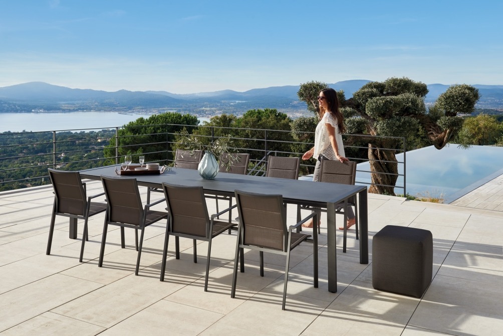 outdoor ceramic dining table with batyline chairs in black and nice view 
