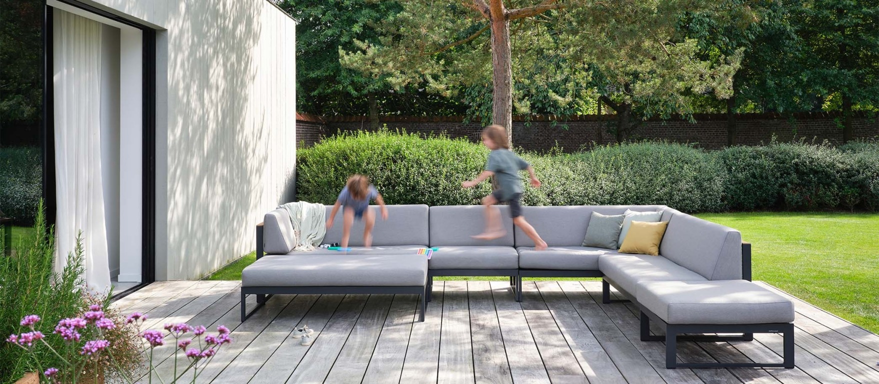 kids jumping in outdoor lounge set - Landscape Teak