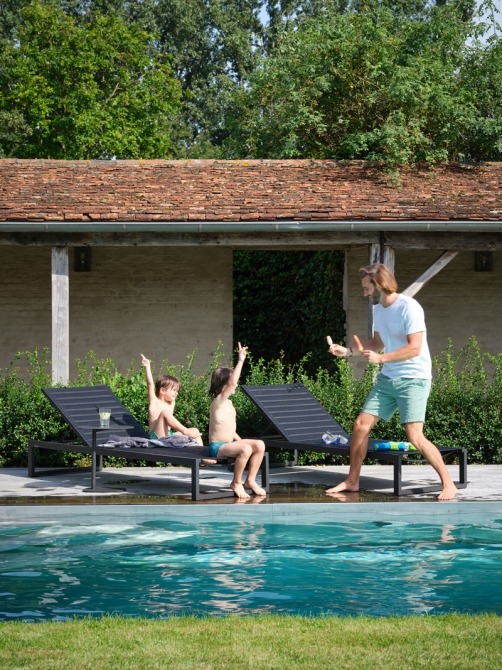 father with kids on loungers by the pool