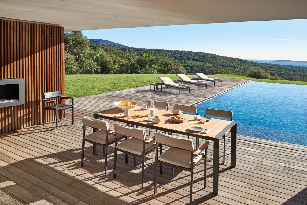 Alexa extendable table on terrace by the pool with sunloungers on the background
