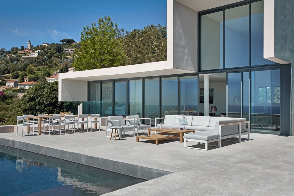 Natural teak coffee tables and dining table on terrace next to lounge set